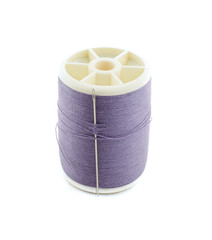 Spool of purple thread and needle on white background