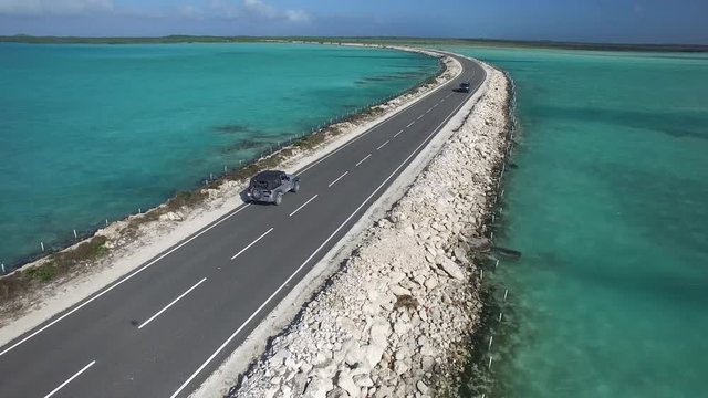 Car drives on coastal road, Turks and Caicos aerial