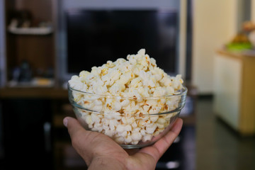 Close up man holding a bowl with popcorn
