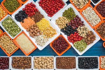Multicolor dried legumes in container flay lay on blue plank for background, Different dry grain for eating healthy, diet and healthy lifestyle, Collection of dried legumes organic for cooking