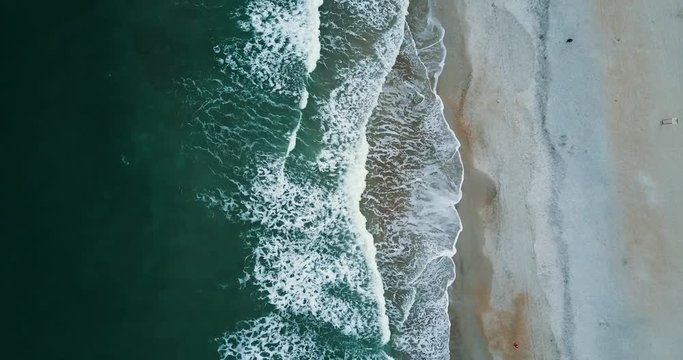 Overhead aerial, waves crash on beach in Wilmington