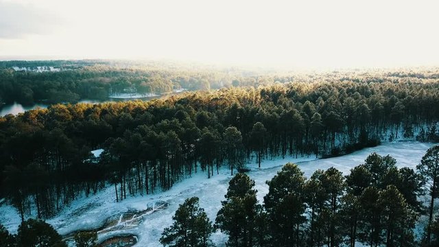 Aerial, sun shines over winter landscape