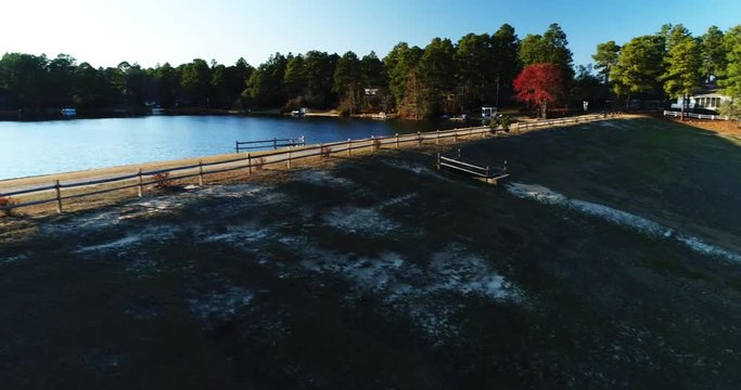 Pan left aerial, sun shines over lake in North Carolina