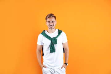 Young man with trendy hairstyle on color background