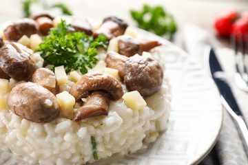 Tasty risotto with mushrooms on plate, closeup