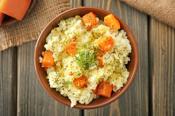 Bowl with delicious pumpkin risotto on wooden table