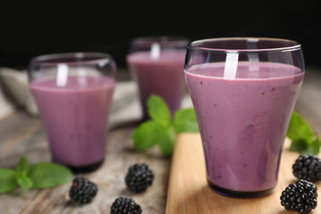 Glasses with tasty blackberry yogurt smoothies on table