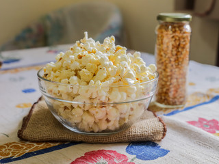 glass bowl with popcorn and corn seeds