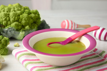 Plate with healthy baby food on light table