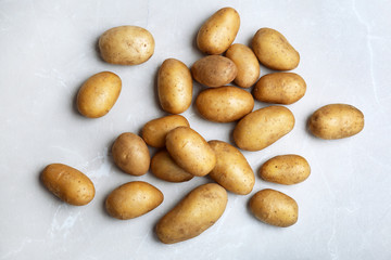 Fresh ripe organic potatoes on grey background, top view
