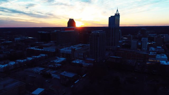 Wide aerial, sunset over Raleigh skyline