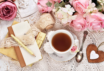 retro style flatlay of tea, bunch of flowers and laces