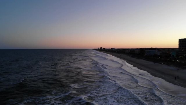 Pan right aerial, sunset over Carolina Beach
