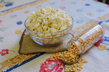 glass bowl with popcorn and corn seeds