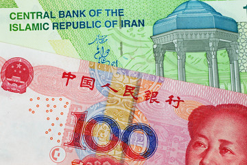 A close up image of a Chinese 100 Yuan bank note with an Iranian 10000 rial note