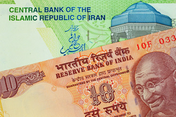 A close up image of an Indian 10 rupee bank note with an Iranian 10000 rial note