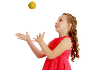 The little girl throws the ball up