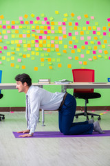 Man in the office with many conflicting priorities doing exercis