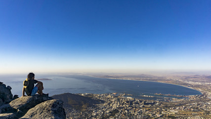 A sitting man at the top of Table Mountain, Cape Town, South Africa