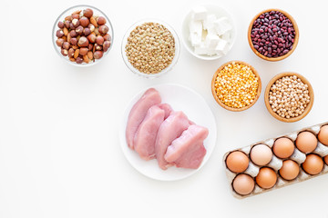 Healthy food. Products rich protein and fiber. Legumes, nuts, low-fat cheese, meet, eggs. Raw beans, chickpeas, lentil, almond, hazelnut on white background top view copy space