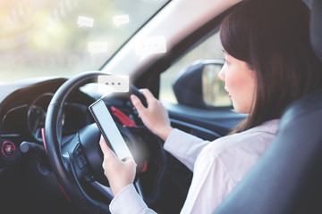 Woman texting message by smart phone while on a car