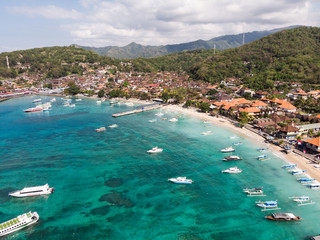 Obraz premium Stunning aerial view of Padang Bai beach, harbor and town in Northeast Bali in the famous Indonesia island on a sunny day.