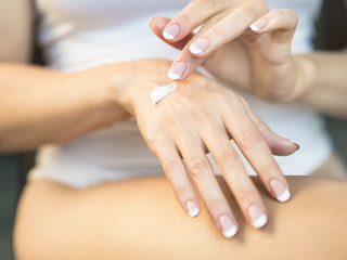 Obraz na płótnie Canvas Young woman applying hand cream, closeup view