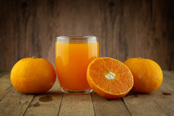 Glass of fresh orange juice on vintage wood table with copy space 