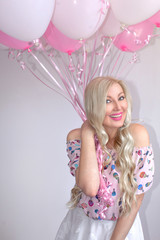 Obraz na płótnie Canvas Beautiful blond woman with pink and white balloons. Joyful emotions. Celebration.