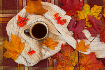 Naklejka na ściany i meble Coffee, scarf and autumn leaves on warm brown plaid. Autumn flat lay.