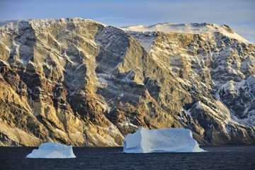 Icebergs in the background of picturesque Greenland mountains.