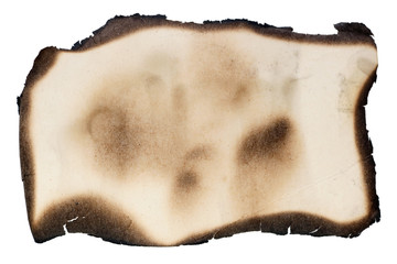 A small piece of yellow aged vintage  paper with burned  black edges. Isolated