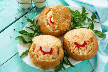 Snack on the festive table. Bun stuffed with shrimp salad and red caviar.