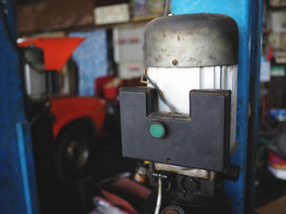 Close up motor car lifting in garage. Auto repair service
