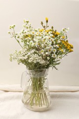 Vase with bouquet of wildflowers. Bouquet of wild flowers in glass pitcher.