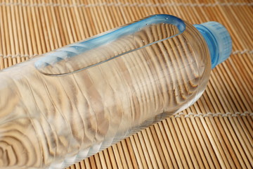 fitness concept with bottle of water over wooden background
