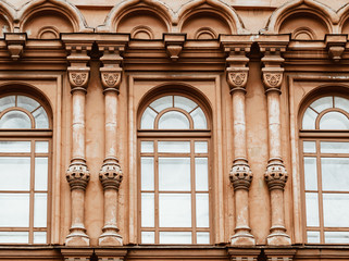 Fototapeta na wymiar View of windows and details on an exterior of the medieval building in Saint Petersburg, Russia.