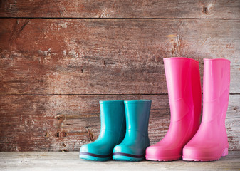 rubber boots on old wooden background - obrazy, fototapety, plakaty