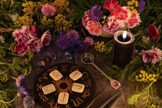 Still life with old runes, zodiac circle, black candle, flowers and ritual objects. Mystic background with ritual esoteric objects, occult, fortune telling and halloween concept
