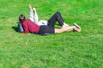 Girls lie on the green grass