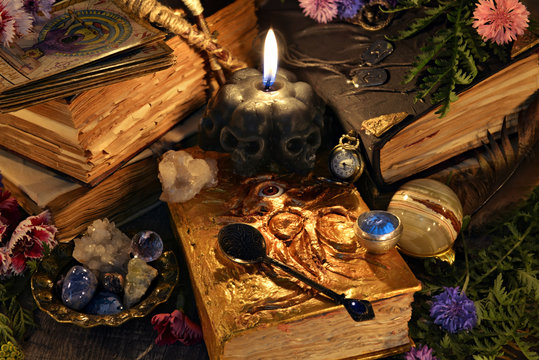 Still life with antique witch book, black candle and ritual objects. Mystic background with ritual esoteric objects, occult, fortune telling and halloween concept