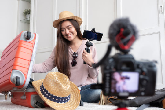 Asian young female blogger recording vlog video with vacation preparing to travel trip at home.online influcencer on social media concept.