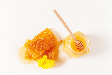 jar of honey and stick isolated on white background