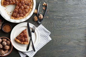 Traditional walnut pie with spices and nuts on dark wooden table, top view