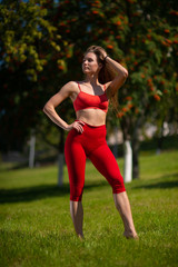 Young attractive woman standing on a green lawn, ready for training