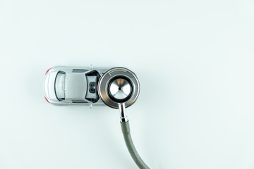 Stethoscope checking up the car on white background, Concept of car check up, repair and maintenance..