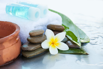 Two bottles with oil for massage. Spa concept with flowers and leaves
