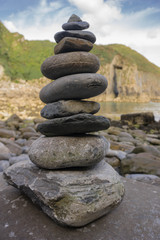 Fototapeta na wymiar Rock Pile on a beach in South Wales with a soft background of the Church Doors