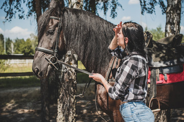 Nice scene woman with a horse in the countryside. Concept of horse and human. Portrait of vintage style artistic woman walking with horse outdoors 