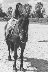 Romantic scene woman with a horse in the countryside. Concept of horse and human. Portrait of vintage style artistic woman walking with horse outdoors in turquoise dress